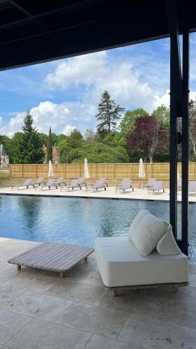 a pool with lounge chairs and a bed next to it at Château De Razay in Céré-la-Ronde