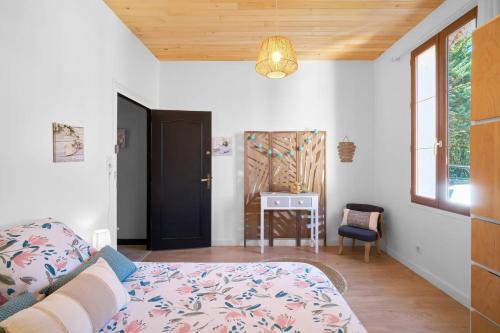 a bedroom with a bed and a table and a window at L'Envol - Oasis Ressource in Eyliac
