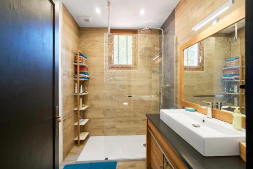 a bathroom with a sink and a glass shower at L'Envol - Oasis Ressource in Eyliac