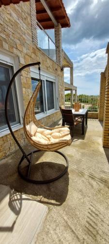 a swing chair sitting on the patio of a house at Blue Paradise Villa in Karianí
