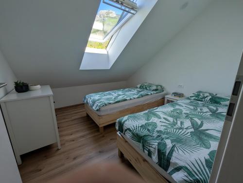 two beds in a room with a window at Apartmaji Pippi in Bovec