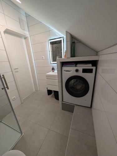 a small bathroom with a washer and dryer at Apartmaji Pippi in Bovec