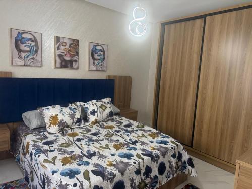 a bedroom with a bed with a blue and white blanket at tanger in Oulad Akkou