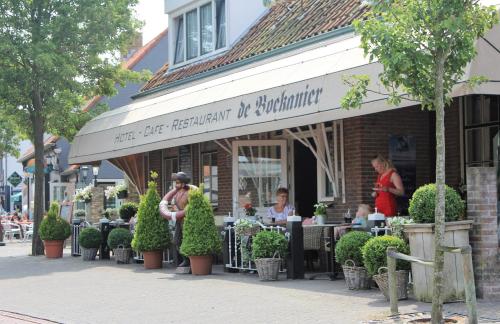 a group of people sitting at tables outside of a restaurant at Hotel Restaurant de Boekanier in Vrouwenpolder