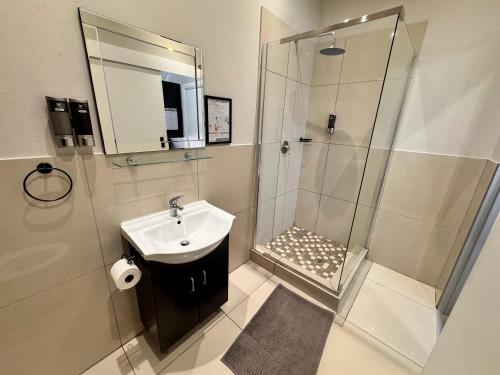 a bathroom with a sink and a shower at Faith, Hope & Love Self Catering in Port Elizabeth