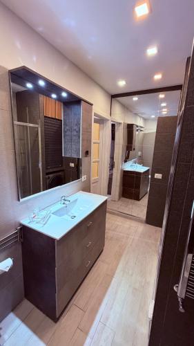 a bathroom with a sink and a large mirror at Urban & B in Civitavecchia