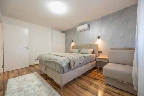 a bedroom with a large bed and a couch at Vila Lux in Tešanovića Mala