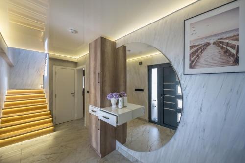 a hallway with a round mirror and a staircase at Vila Lux in Tešanovića Mala