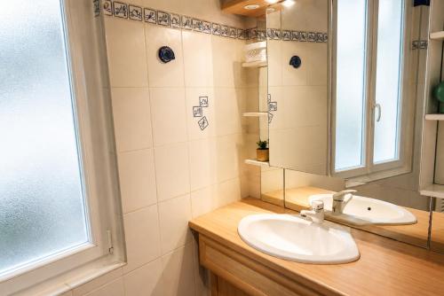 a bathroom with a sink and a mirror and a window at Le Saint-Roch Issoudun - Charm & Private Terrace in Issoudun