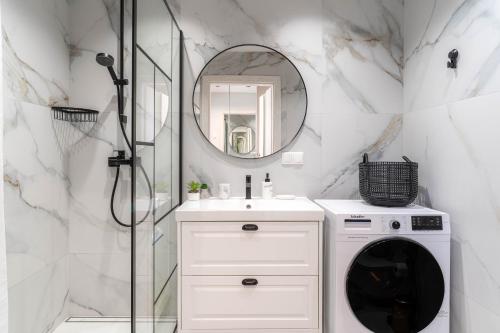 a bathroom with a washing machine and a mirror at Skylum 17th Floor Apartment in Vilnius