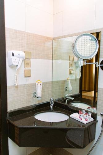 a bathroom with a sink and a mirror at Zawaya Almasia Hotel 2 in Medina
