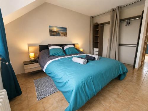a bedroom with a large bed with blue sheets at Le Saint-Cyr Issoudun - Cosy, Spacious & Downtown in Issoudun
