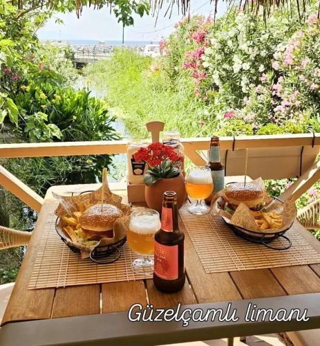 a picnic table with two bottles of beer and baskets of food at Bohem Pansiyon in Kuşadası