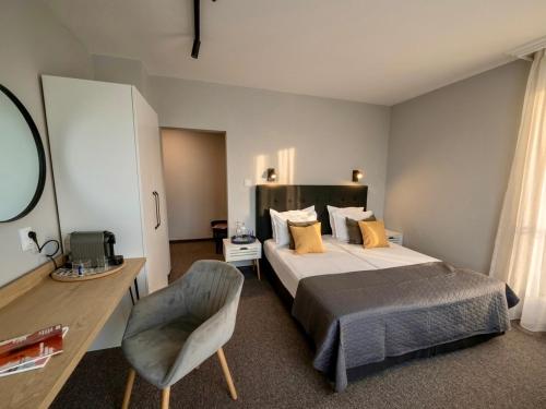 a bedroom with a bed and a desk and a chair at HOTEL BRIZ - Free Parking in Burgas