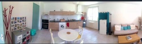 a kitchen and living room with a table and chairs at Hébergement TRAVAILLEURS in Monestrol