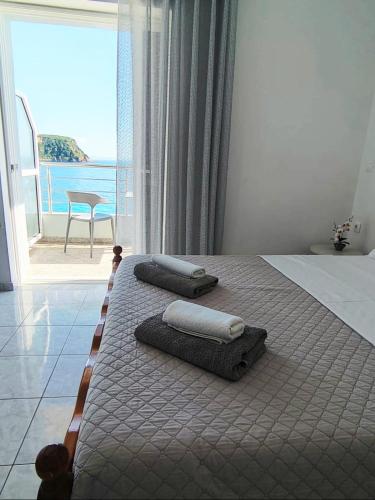 a bedroom with a bed with towels and a view of the ocean at NaDim rooms in Himare