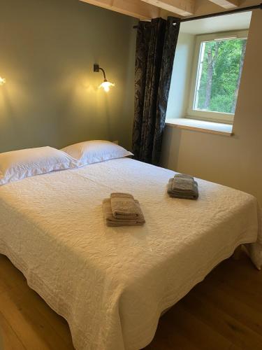 a bedroom with a bed with two towels on it at La Pousterle - Gîte in Salettes