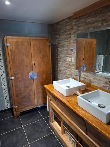 a bathroom with two sinks and a large mirror at Kazh bihan in Guissény
