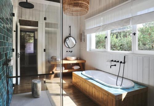 a bathroom with a tub and a glass shower at Quinta Da Comporta - Wellness Boutique Resort in Comporta
