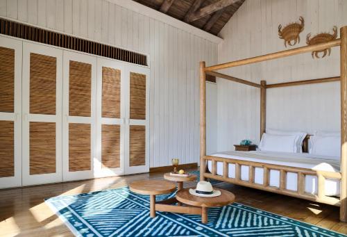 a bedroom with a canopy bed and a rug at Quinta Da Comporta - Wellness Boutique Resort in Comporta