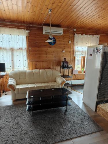 a living room with a couch and a refrigerator at Ranta mökki in Kouvola