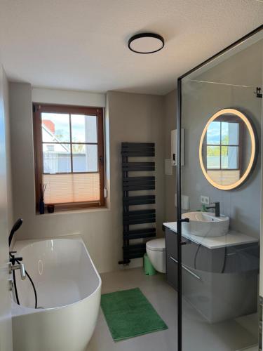 a bathroom with a tub and a sink and a mirror at NEU Apartment Lotta in Senftenberg