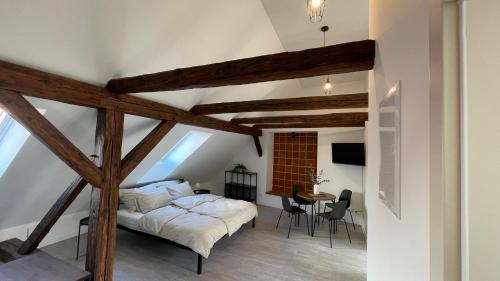 an attic bedroom with a bed and a table at Dvorek110 in Roudnice nad Labem
