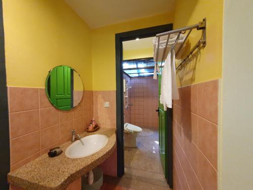 a bathroom with a sink and a toilet and a mirror at Golden Snapper Guest House in Yan
