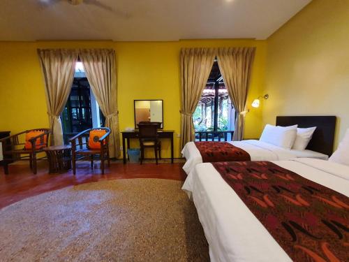 a hotel room with two beds and a desk at Golden Snapper Guest House in Yan