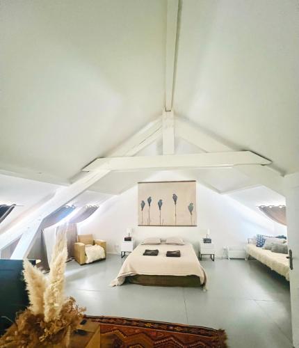 a white room with a bed and a couch at Loft atelier quatre in Ussel