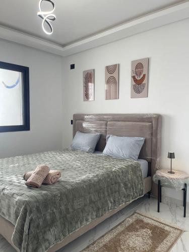 a bedroom with a large bed and a window at Appart laouina in El Aouina Station