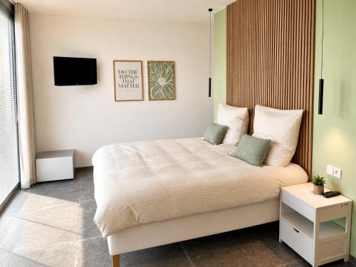 a bedroom with a bed and a tv on the wall at Le Cocon Galhausen in Saint-Vith