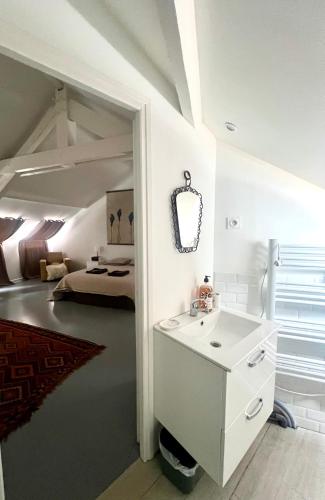 a bathroom with a sink and a room with a bed at Loft atelier quatre in Ussel