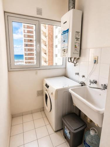 a small bathroom with a washing machine and a sink at Departamento Mara in Puerto Madryn