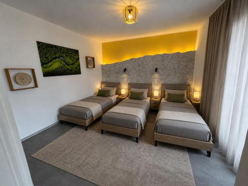a living room with four beds and a yellow wall at Ada&Cris Apartament in Klotten