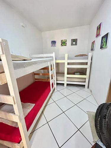 a room with two bunk beds and a tiled floor at Canoa Roots Hostel & Camping in Canoa Quebrada