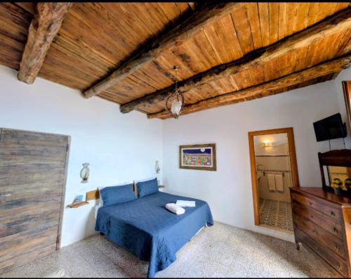 a bedroom with a blue bed and a mirror at Mareluna Cottage in Conca dei Marini