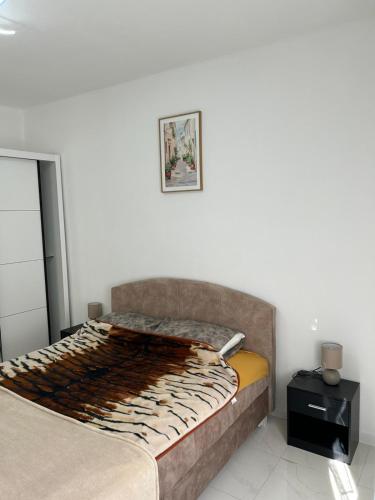 a bedroom with a bed and a white wall at E&L Apartments in Kovačina