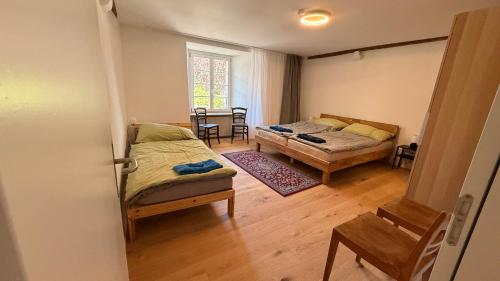 a bedroom with two beds and a table and chairs at a knight's townhouse in Büren an der Aare