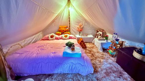 a bedroom with a teddy bear on a bed at มองวิวภูชี้ฟ้า รีสอร์ท in Ban Seng Choi