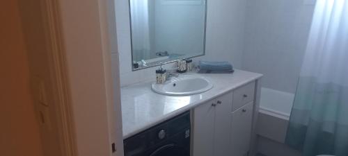 a bathroom with a white sink and a mirror at Magdalena Cozy Apartment in Sparta