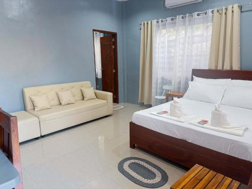 a living room with a bed and a couch at Pineda Villa in Puerto Princesa City