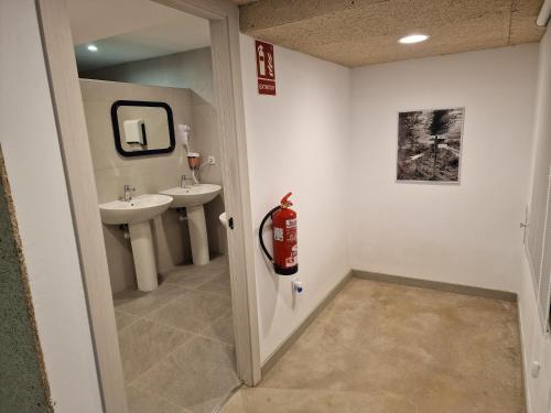a bathroom with two sinks and a fire extinguisher at Albergue Cafetería La Parada in Villarquemado