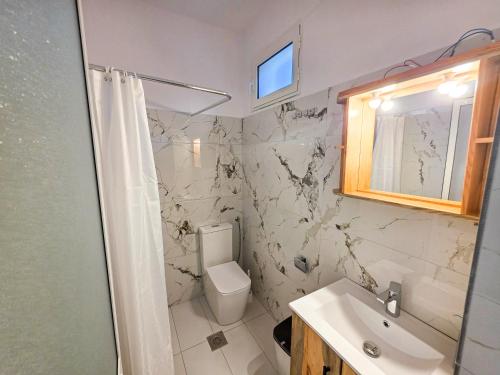 a bathroom with a toilet and a sink at Hotel Restaurant Ujimira in Radomirë