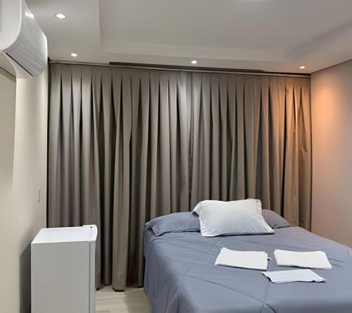 a bedroom with a large bed and a curtain at Maryah Prime Studio Hotel Extrema + breakfast in Extrema
