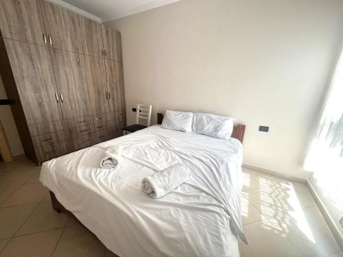 a bedroom with a white bed with towels on it at B2 Apartment 4 in Kashari