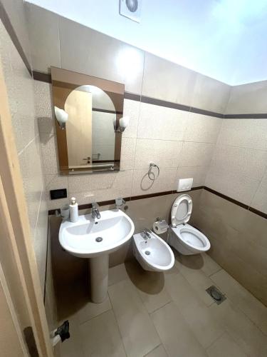 a bathroom with a sink and a toilet and a mirror at B2 Apartment 4 in Kashari