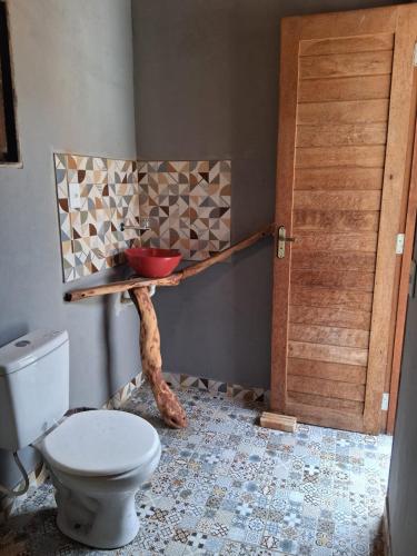 a bathroom with a toilet and a bowl on a shelf at Bicho Grilo Hostel in Atins