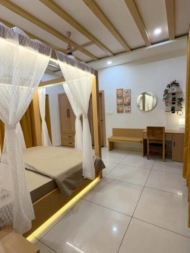a bedroom with a bed with curtains and a desk at Luxury private pool villa for families & groups in Ujjain