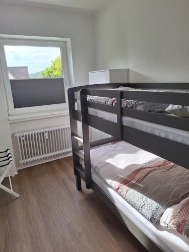 a bedroom with two bunk beds and a window at Ferienwohnung Bever in Bad Karlshafen